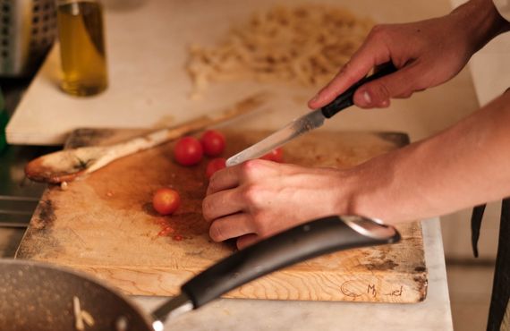 Krojenie pomidorków koktajlowych na desce - przygotowanie składników na domowy fast food na keto