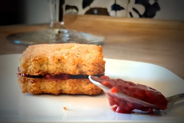 Herbatniczek keto z łyżeczką dżemu malinowego bez cukru obok