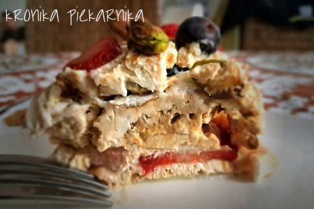 Keto tort bezowy z kremem pistacjowym i owocami - przekrój z zielonym nadzieniem
